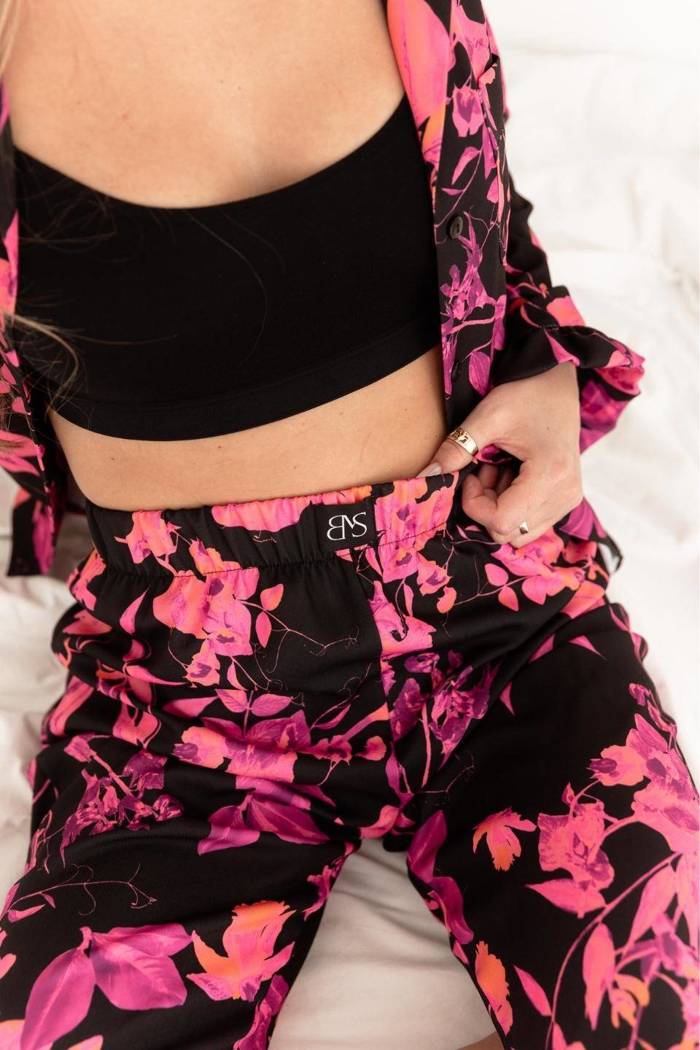 Spodnie damskie  LETISSIA -  długie spodnie w różowe kwiaty na czarnym tle. 