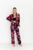 Spodnie damskie LETISSIA - długie spodnie w różowe kwiaty na czarnym tle.
