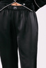 Spodnie Odette - satynowe w kolorze głębokiej czerni z ozdobnym białym pajpingiem u dołu nogawki